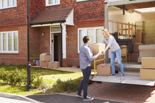 Professional movers carrying furniture from a Chiswick flat